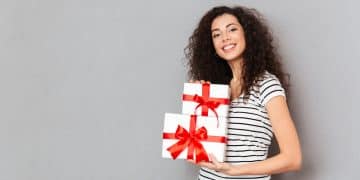 Great emotions of young woman in striped t-shirt holding two gif